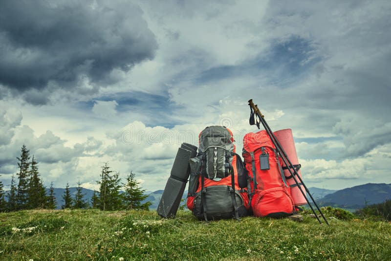 Backpacks in the Mountains Overlooking the Mountains on the Green Grass