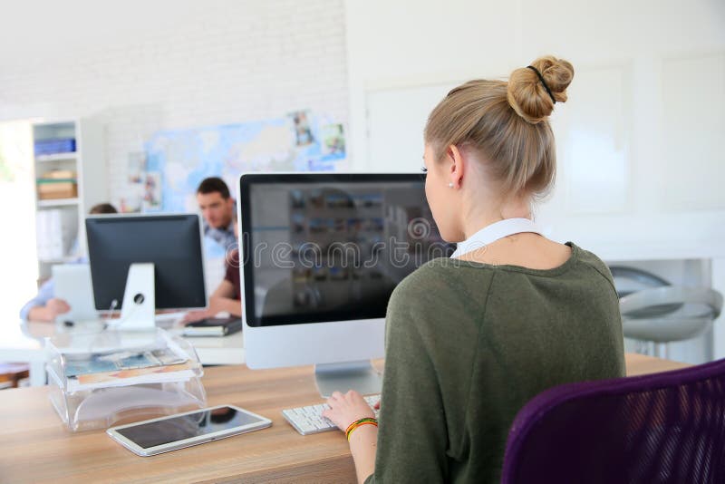 Backview of young student girl working on computer