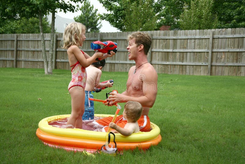 Boys and Girl with Dad in the kiddie pool. Boys and Girl with Dad in the kiddie pool.