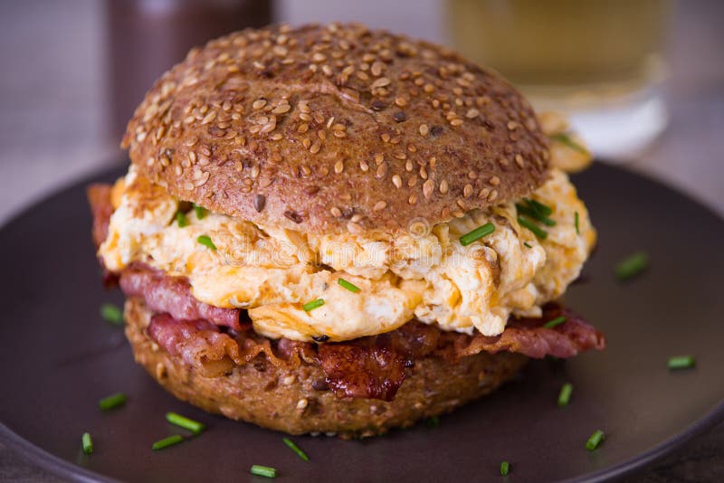 Bacon och förvanskad ägghamburgare royaltyfria bilder Bacon och förvanskad ägghamburgare royaltyfria bilder