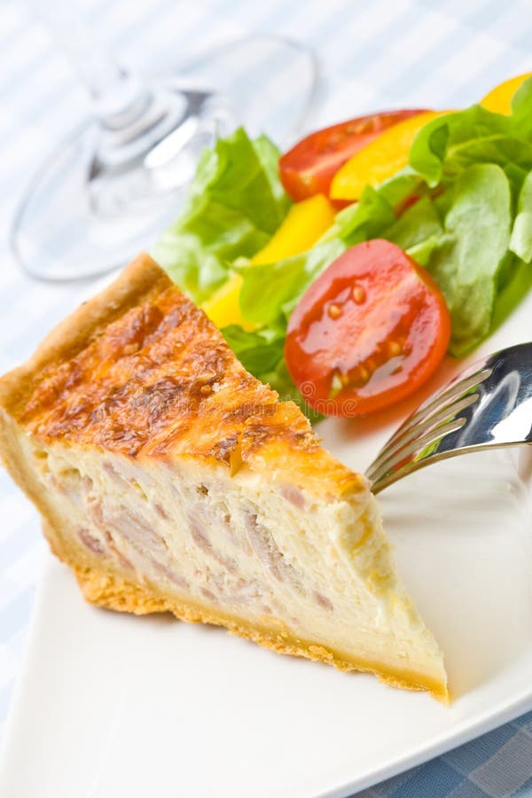 Quiche con pancetta insalata in un piatto.