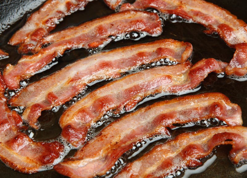 Bacon rashers being cooked in frying pan. Frying pan stock images, royalty-free photos and pictures