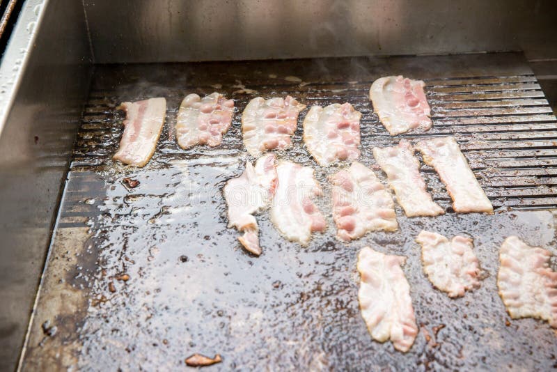 Baconplak op het fornuis wordt geroosterd dat hoge calorieën en vet rokerig die varkensvlees op het fornuis wordt geroosterd royalty-vrije stock afbeelding Baconplak op het fornuis wordt geroosterd dat hoge calorieën en vet rokerig die varkensvlees op het fornuis wordt geroosterd royalty-vrije stock afbeelding