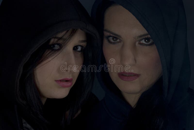 Bad girls with hood in darkness stock photos