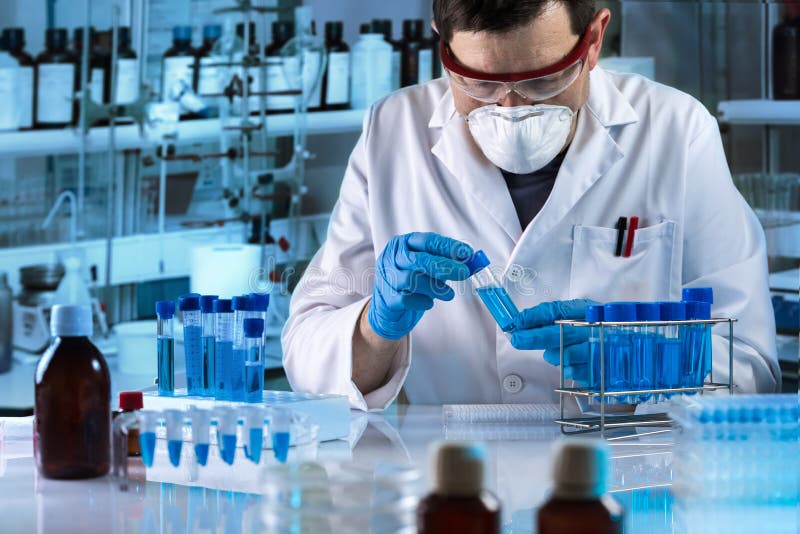 Badacz pracuje z próbką błękitny fluid w tubce dla analizy w laboratorium naukowym obrazy stock Badacz pracuje z próbką błękitny fluid w tubce dla analizy w laboratorium naukowym obrazy stock