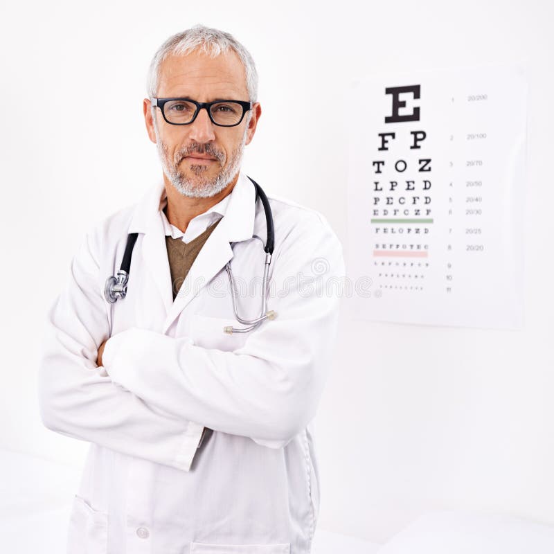 Badare ai tuoi occhi. ritratto di un adulto optometrista maschio in piedi nel suo ufficio con una cartina dell'occhio fotografia stock
