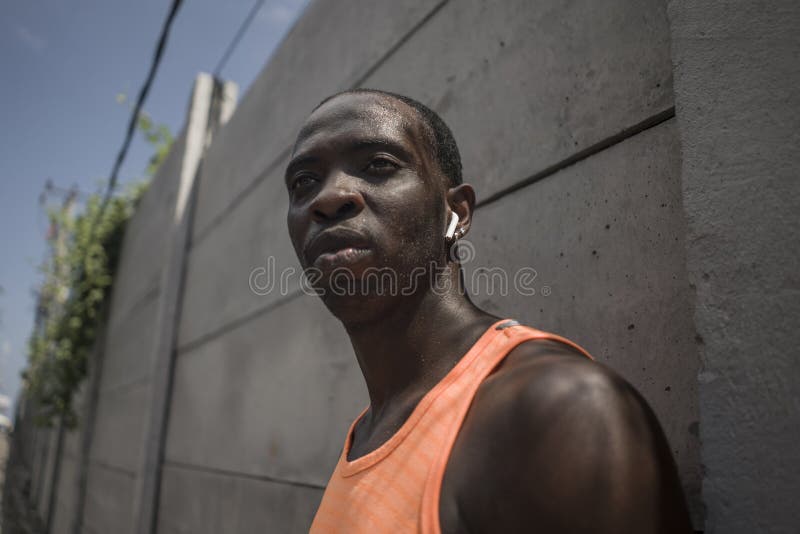 Badass style portrait of young attractive and athletic black afro American sport man in running singlet looking cool on concrete royalty free stock image Badass style portrait of young attractive and athletic black afro American sport man in running singlet looking cool on concrete royalty free stock image