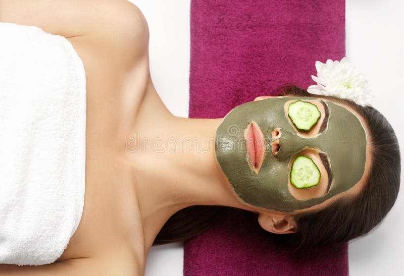 Badekurort Clay Mask Frau mit Lehmgesichtsmaske und Gurken auf Auge lizenzfreie stockfotos Badekurort Clay Mask Frau mit Lehmgesichtsmaske und Gurken auf Auge lizenzfreie stockfotos