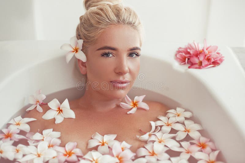 Badekurort entspannen sich Blondes genießendes Bad mit tropischen Blumen des Plumeria Gesundheit und Sch?nheit Nahaufnahme-schöne lizenzfreies stockfoto Badekurort entspannen sich Blondes genießendes Bad mit tropischen Blumen des Plumeria Gesundheit und Sch?nheit Nahaufnahme-schöne lizenzfreies stockfoto