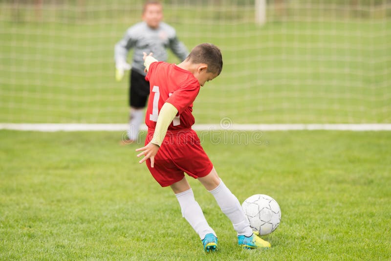 Badine le football du football - les joueurs d'enfants sont assortis sur le terrain de football
