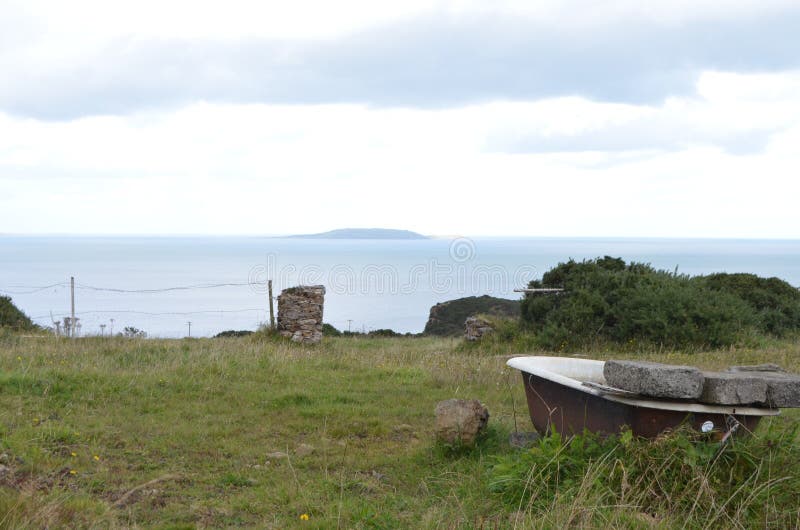 Badkuip op een Landelijk Gebied door de Overzeese Kust in Howth, Ierland stock foto Badkuip op een Landelijk Gebied door de Overzeese Kust in Howth, Ierland stock foto