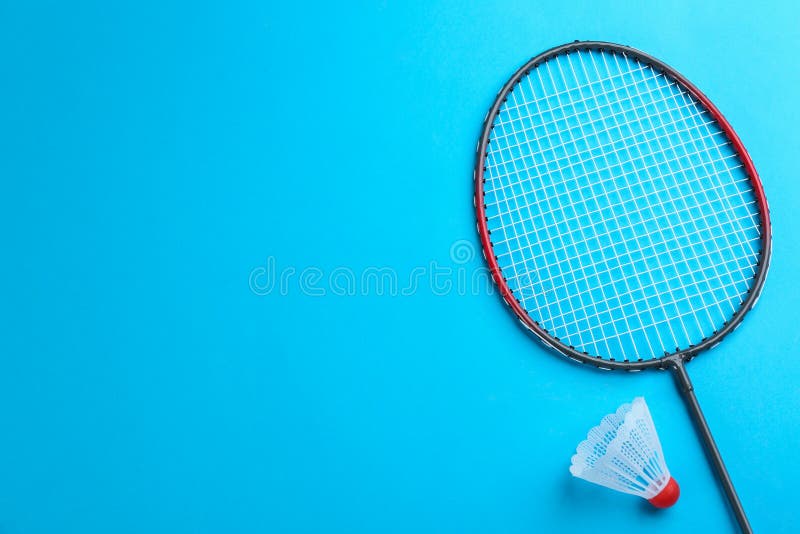 Badminton Racket and Shuttlecock on Light Blue Background, Flat Lay