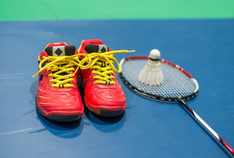 Badminton red shoes with blurred shuttlecock and racket on court