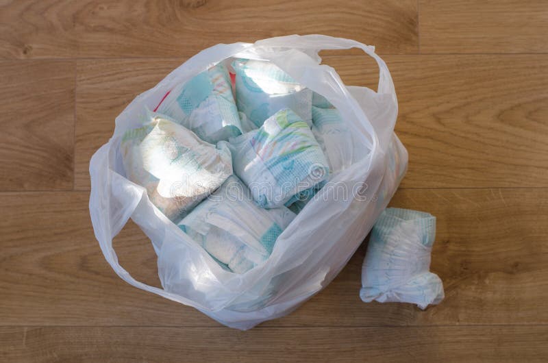 A bag full of dirty baby`s diapers standing on the floor high stock ph...