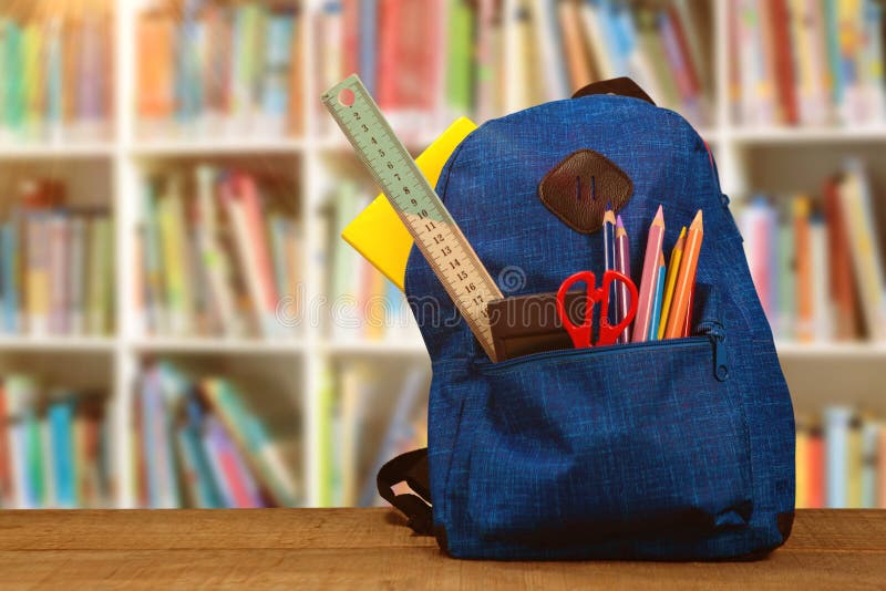 Composite image of bag with school supplies on wooden table
