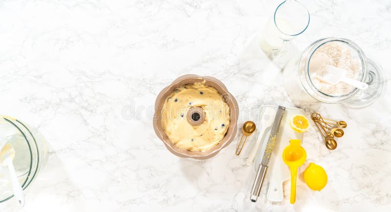 Flat lay. Delicately transferring the cake batter into the pre-greased bundt cake pan, setting the stage for a successful baking process. Flat lay. Delicately transferring the cake batter into the pre-greased bundt cake pan, setting the stage for a successful baking process.