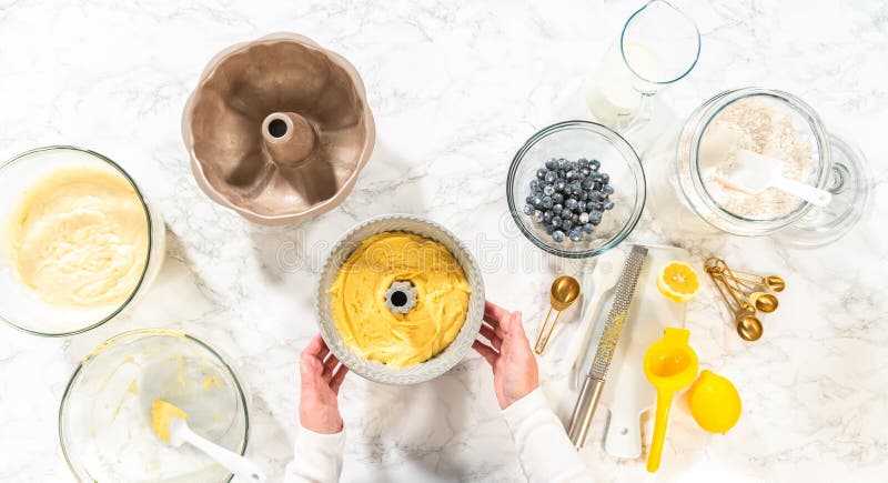 Flat lay. Delicately transferring the cake batter into the pre-greased bundt cake pan, setting the stage for a successful baking process. Flat lay. Delicately transferring the cake batter into the pre-greased bundt cake pan, setting the stage for a successful baking process.