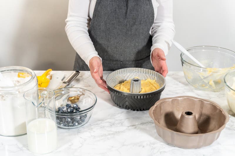 Delicately transferring the cake batter into the pre-greased bundt cake pan, setting the stage for a successful baking process. Delicately transferring the cake batter into the pre-greased bundt cake pan, setting the stage for a successful baking process.