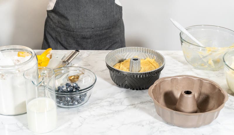 Delicately transferring the cake batter into the pre-greased bundt cake pan, setting the stage for a successful baking process. Delicately transferring the cake batter into the pre-greased bundt cake pan, setting the stage for a successful baking process.