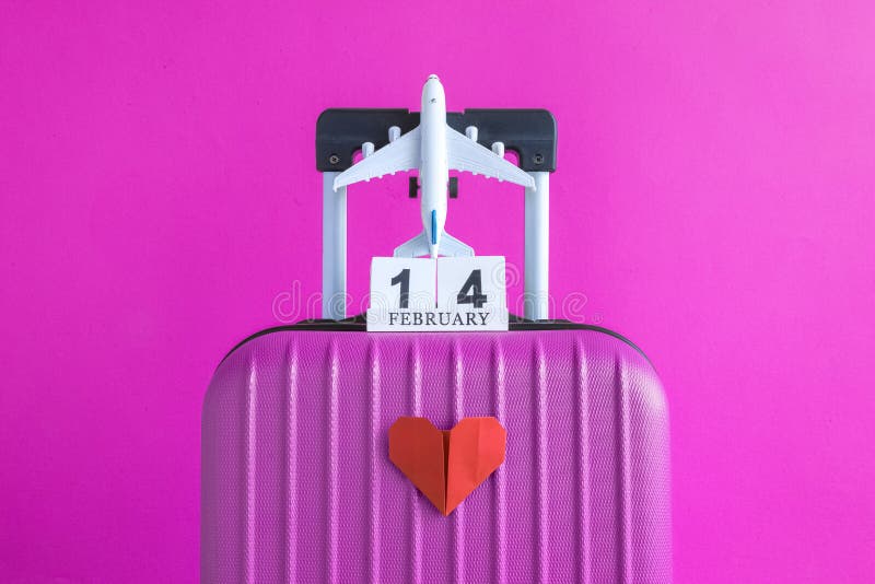 Bagage med kalendern för valentindagdatum och flygplan med pappershjärta på minimalistic semesterbegrepp för rosa bakgrund arkivbild Bagage med kalendern för valentindagdatum och flygplan med pappershjärta på minimalistic semesterbegrepp för rosa bakgrund arkivbild