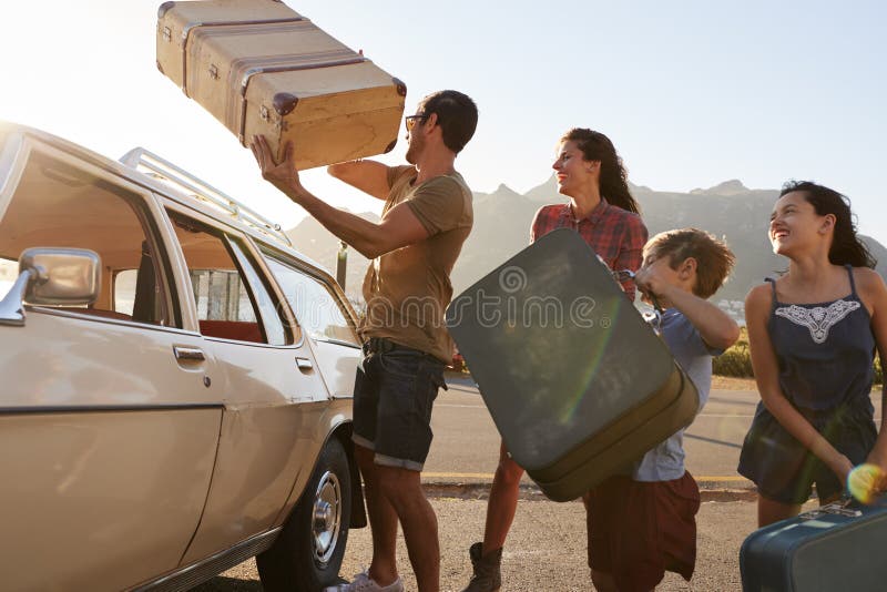 Bagagem da carga da família na grade de tejadilho do carro pronta para a viagem por estrada