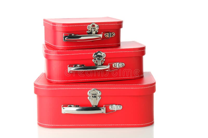 A set of matching luggage pieces stacked on top of each other. Three different sizes of red suitcase isolated on white with a slight reflection. A set of matching luggage pieces stacked on top of each other. Three different sizes of red suitcase isolated on white with a slight reflection.