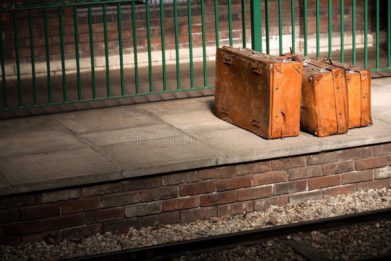 Vintage baggage suitcases on an empty railway platform. Vintage baggage suitcases on an empty railway platform