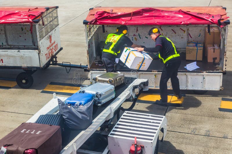 Bagages thaïlandais de passager de charge de personnel au sol de Lion Air sur l'airpla image stock Bagages thaïlandais de passager de charge de personnel au sol de Lion Air sur l'airpla image stock