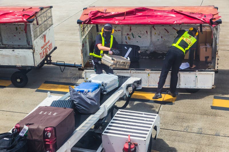 Bagages thaïlandais de passager de charge de personnel au sol de Lion Air sur l'airpla image stock Bagages thaïlandais de passager de charge de personnel au sol de Lion Air sur l'airpla image stock