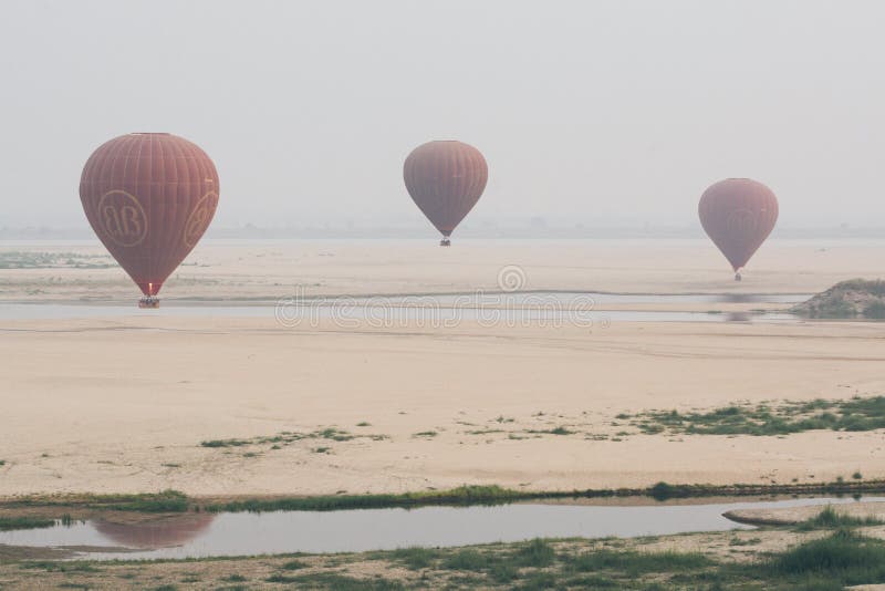 Bagan, Myanmar - March 2019: hot air balloons landing near Irrawaddy river royalty free stock photos Bagan, Myanmar - March 2019: hot air balloons landing near Irrawaddy river royalty free stock photos