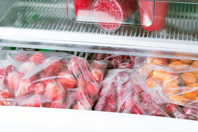 Bagas e frutos congelados nos sacos no congelador, fim acima fotografia de stock Bagas e frutos congelados nos sacos no congelador, fim acima fotografia de stock