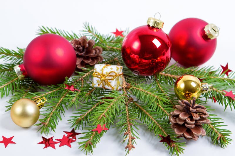 Bagattelle della decorazione di Natale con i rami dell'albero di abete su fondo bianco fotografie stock Bagattelle della decorazione di Natale con i rami dell'albero di abete su fondo bianco fotografie stock