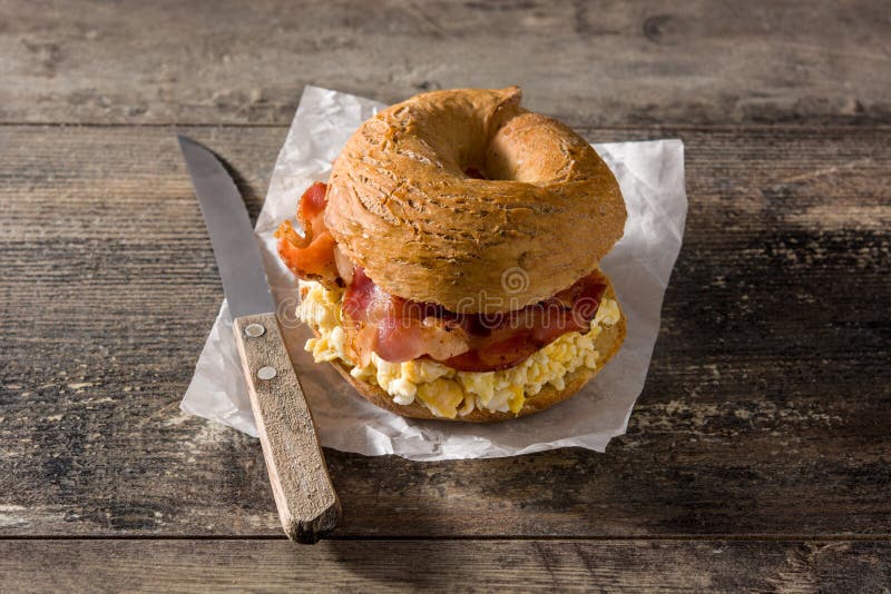 Bagel-boterham met plakband, eieren en kaas op hout stock fotografie Bagel-boterham met plakband, eieren en kaas op hout stock fotografie