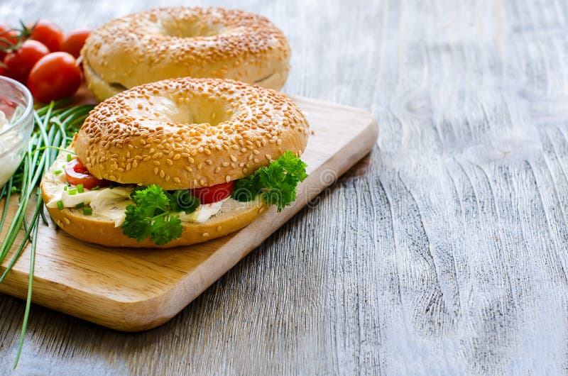 Bagel mit Sahne Käse, Tomaten und Schnittlauche für gesunden Snack lizenzfreies stockbild Bagel mit Sahne Käse, Tomaten und Schnittlauche für gesunden Snack lizenzfreies stockbild