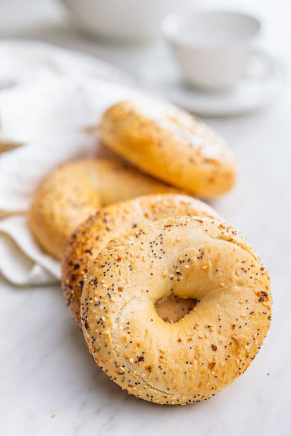 Bagel sprinkled with fried onion, sesame and poppy seeds on kitchen table royalty free stock image
