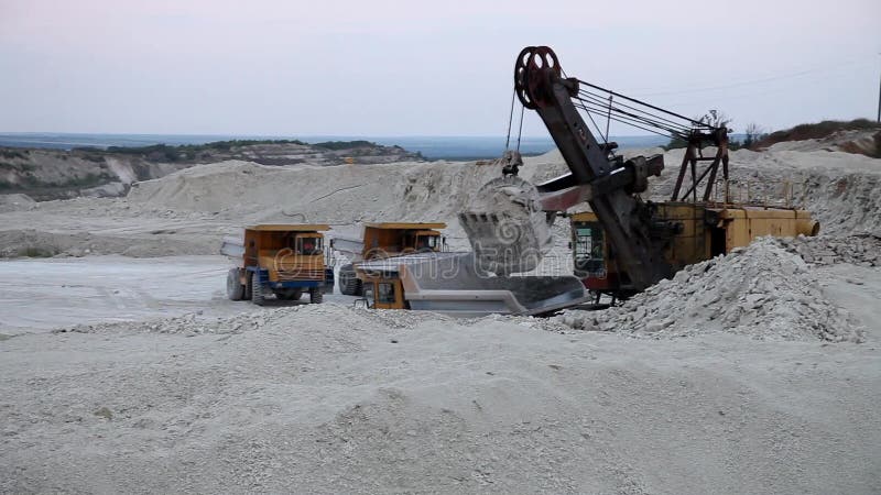 Bagger lädt einen LKW-Felsen im Steinbruch