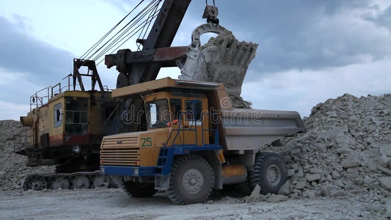 Bagger lädt einen LKW-Felsen im Steinbruch