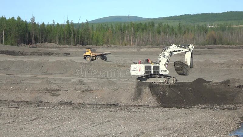 Bagger lädt Stein in Müllwagen