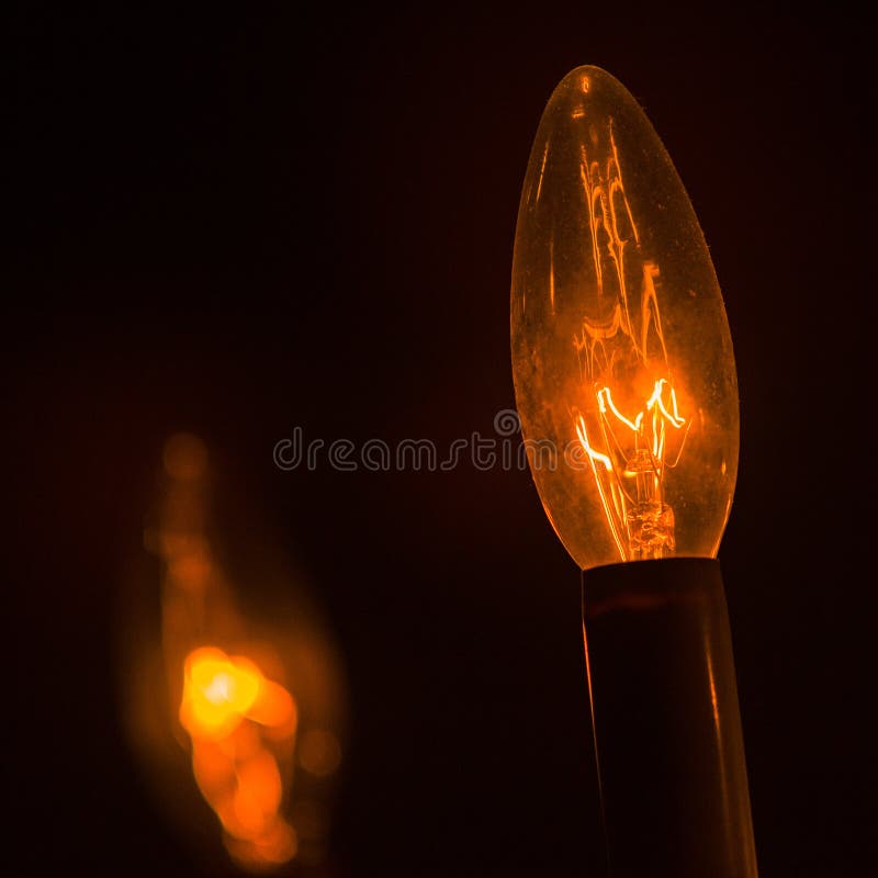 Bagliore arancione della lampadina della luce a incandescenza su potere basso nella casa Bagliore arancione della lampadina della luce a incandescenza su potere basso nella casa