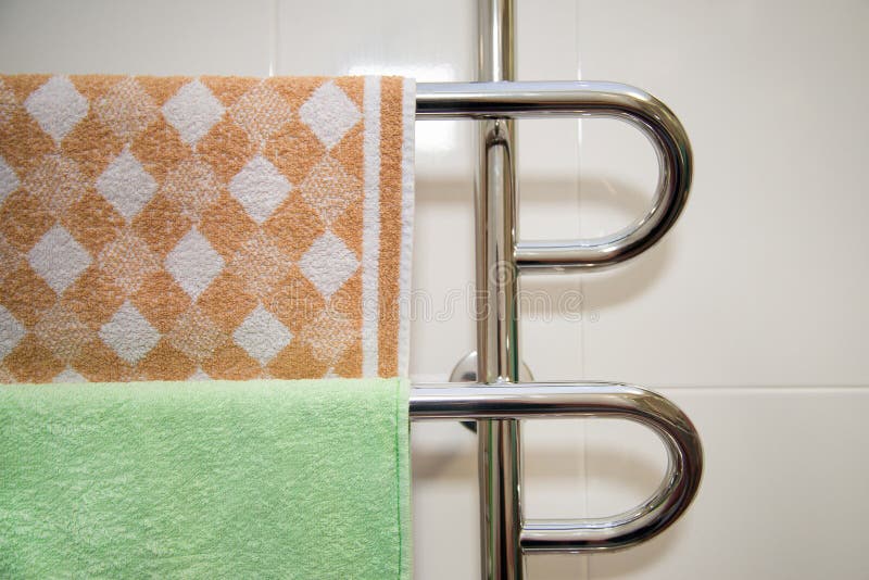 Bagno moderno con lo scaldino dell'asciugamano con l'asciugamano verde e marrone fotografia stock libera da diritti Bagno moderno con lo scaldino dell'asciugamano con l'asciugamano verde e marrone fotografia stock libera da diritti