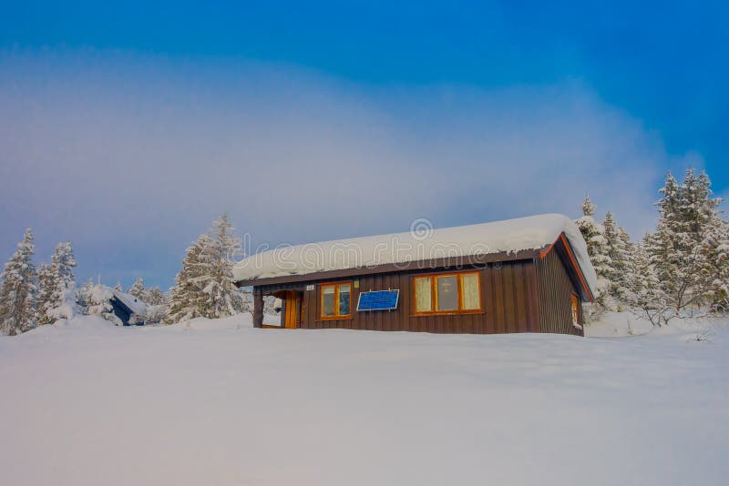 Bagnsasen, Norwegen - April, 02, 2018: Schöne Ansicht im Freien des einsamen hölzernen modernen Hauses bedeckt mit starken Schnee lizenzfreie stockfotografie Bagnsasen, Norwegen - April, 02, 2018: Schöne Ansicht im Freien des einsamen hölzernen modernen Hauses bedeckt mit starken Schnee lizenzfreie stockfotografie