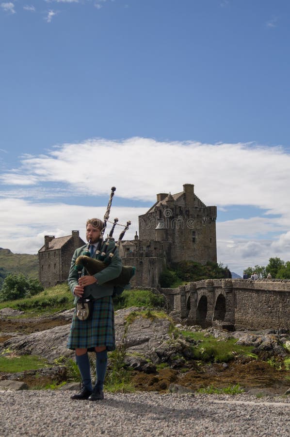 A Bagpiper in Front of Eilean Danon Castle Editorial Stock Image ...
