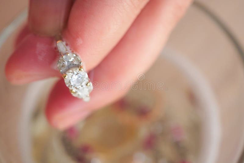 Bague ? diamant de bijoux de cru de nettoyage de main de bijoutier image libre de droits Bague ? diamant de bijoux de cru de nettoyage de main de bijoutier image libre de droits