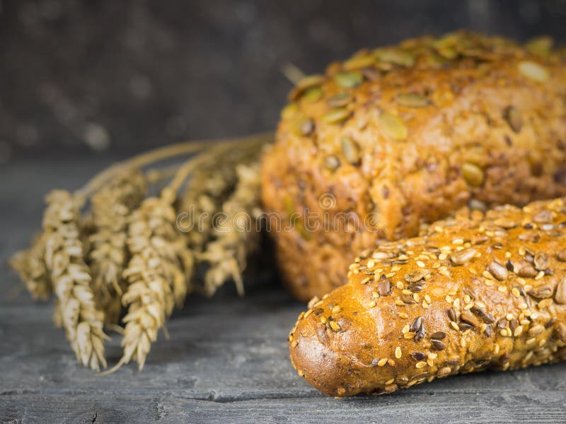 Baguette appena fatte e una pagnotta dalla farina di frumento con le orecchie di grano su una tavola rustica fotografia stock libera da diritti