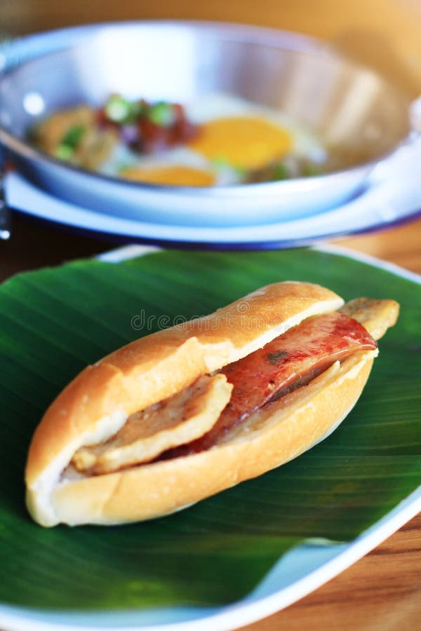 Baguette chlebowa kanapka z serem, baleronem na świeżym Zielonym bananowym liściu i Indochina, smażył jajko z polewami zdjęcia royalty free Baguette chlebowa kanapka z serem, baleronem na świeżym Zielonym bananowym liściu i Indochina, smażył jajko z polewami zdjęcia royalty free