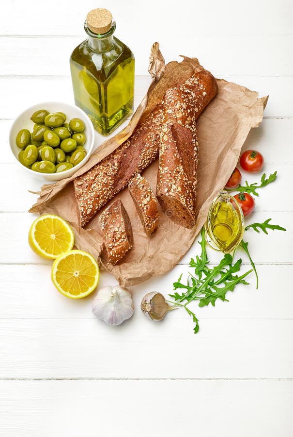 Baguette croustillante avec l'olive verte sur le blanc photo stock