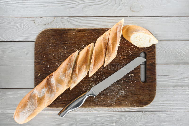 Baguette e coltello affettati fotografia stock Baguette e coltello affettati fotografia stock