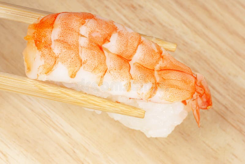 Baguettes retenant des sushi photographie stock libre de droits Baguettes retenant des sushi photographie stock libre de droits