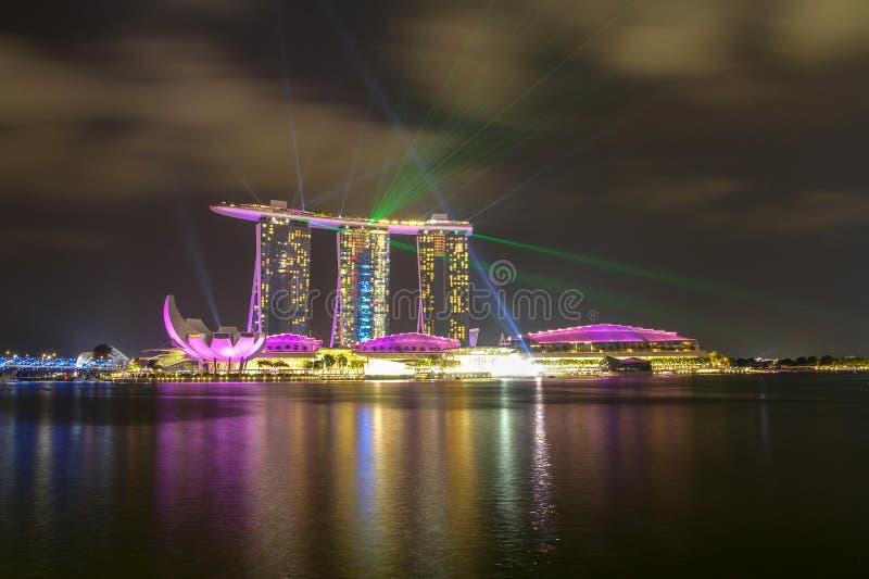 BAH?A DEL PUERTO DEPORTIVO, SINGAPUR - ABRIL 10,2016: demostraci?n del laser en Marina Bay Sands Hotel en noche en Singapur foto de archivo libre de regalías BAH?A DEL PUERTO DEPORTIVO, SINGAPUR - ABRIL 10,2016: demostraci?n del laser en Marina Bay Sands Hotel en noche en Singapur foto de archivo libre de regalías