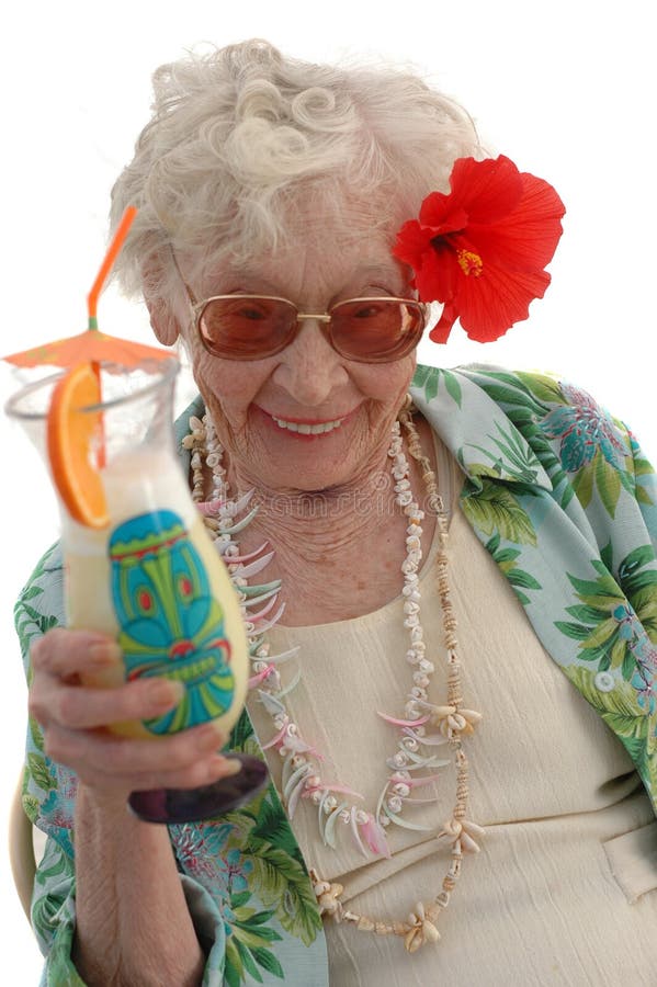 Super senior 80 year old woman with a tropical drink and Hibiscus flower in her hair. Old granny stock images, royalty-free photos and pictures
